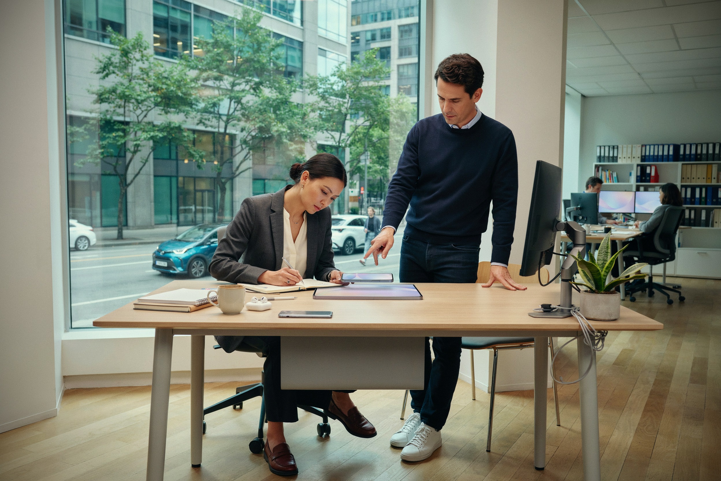 Journalistes analysant l’iPhone Duo dans un bureau moderne